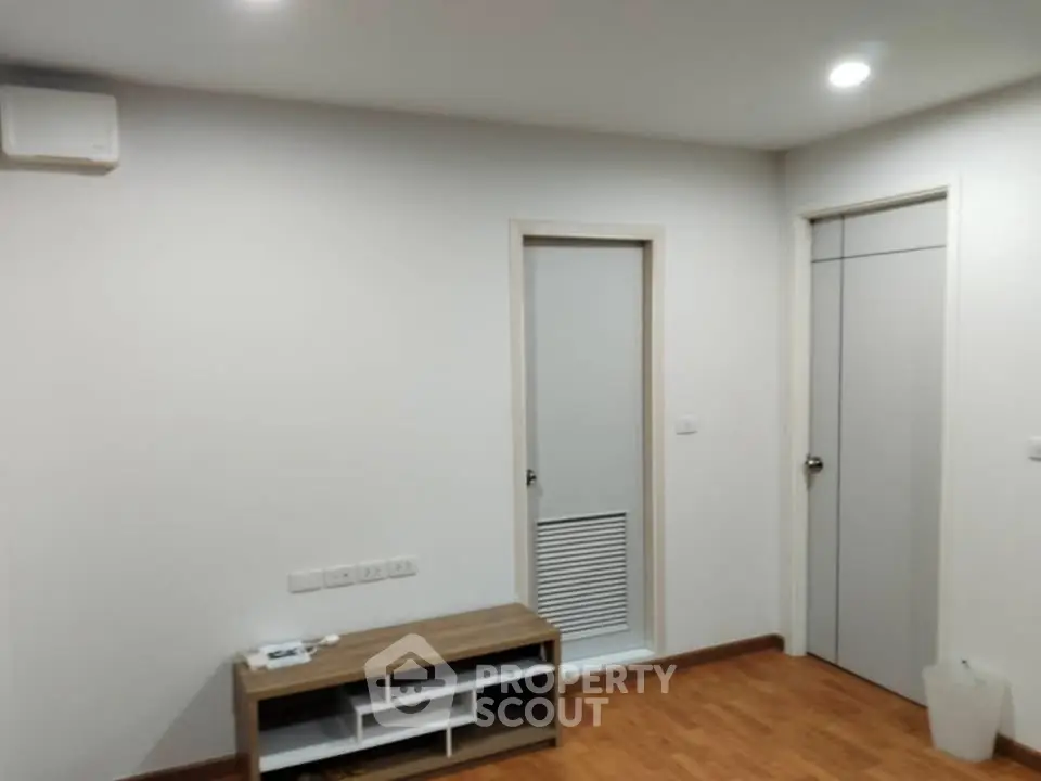Minimalist interior with wooden flooring and modern doors in a cozy living space.