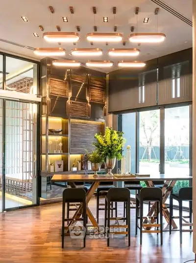 Luxurious dining area with modern lighting and elegant wooden furniture, perfect for sophisticated gatherings.