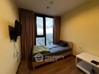 Cozy bedroom with city view, featuring a mounted TV and modern furnishings.