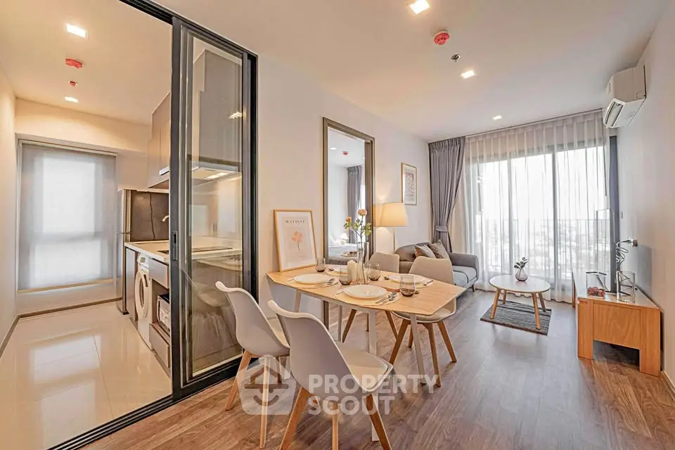 Modern open-plan living room with dining area and kitchen in stylish apartment.