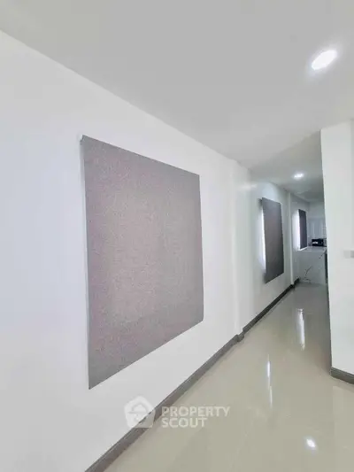 Spacious modern hallway with sleek tile flooring and minimalist wall decor.