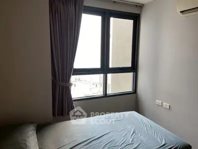 Cozy bedroom with large window and modern air conditioning unit.