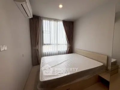 Cozy bedroom with natural light and modern furnishings in a stylish apartment.