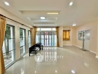 Spacious living room with large windows and elegant curtains