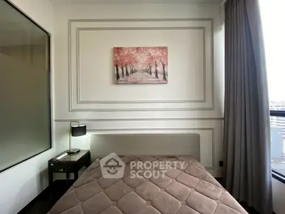 Modern bedroom with elegant decor and large window offering city views.