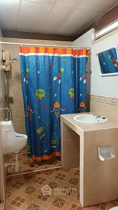 Charming bathroom with playful robot-themed shower curtain and modern fixtures.