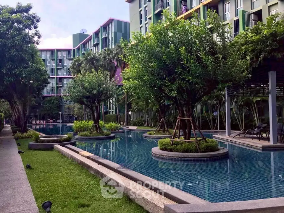 Luxurious apartment complex with serene pool and lush greenery