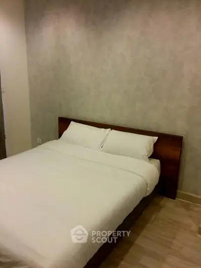 Cozy bedroom with minimalist design and comfortable bed in modern apartment.