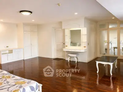 Spacious bedroom with elegant wooden flooring and stylish furniture