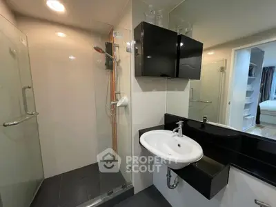 Modern bathroom with glass shower and sleek black cabinetry