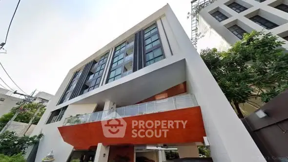 Modern multi-story building with sleek design and large windows in urban setting.