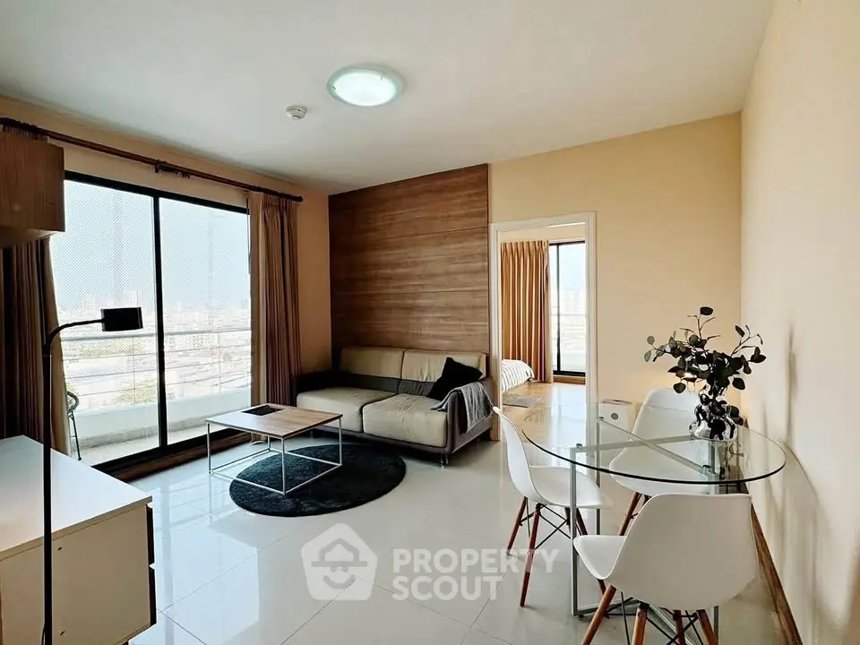 Modern living room with balcony view and stylish furniture in a high-rise apartment.