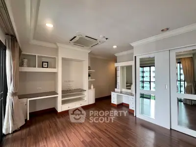 Spacious modern living room with wooden flooring and built-in storage