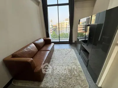 Modern living room with leather sofa and large window overlooking cityscape