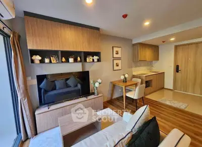 Modern living room with open kitchen, stylish decor, and cozy seating area in a contemporary apartment.