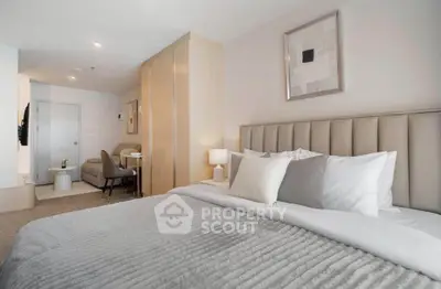 Modern bedroom with stylish decor and cozy seating area in a contemporary apartment.