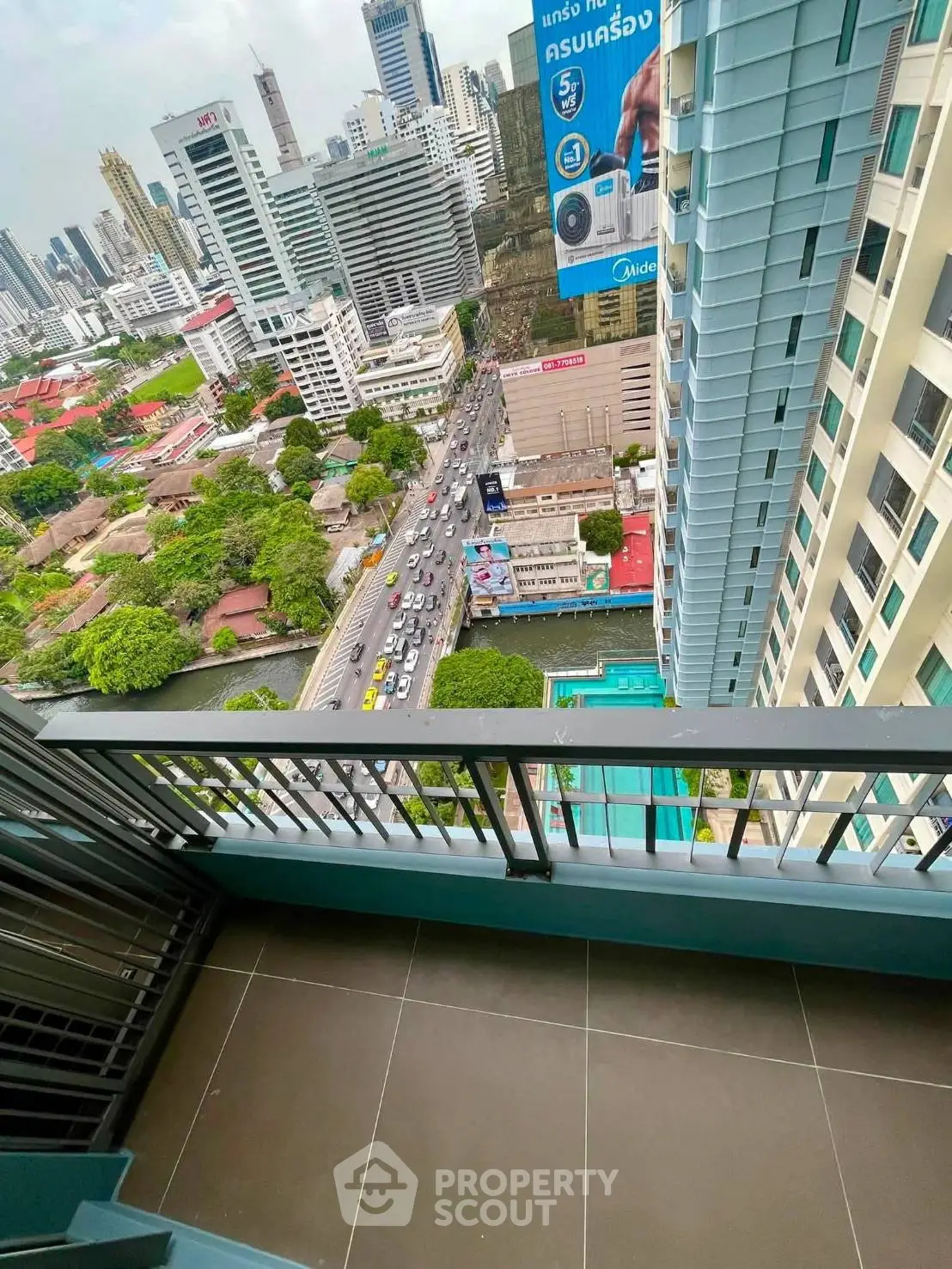 Stunning high-rise balcony view overlooking cityscape and bustling streets, perfect for urban living enthusiasts.