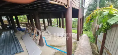 Under-construction elevated structure with lush greenery and pathway