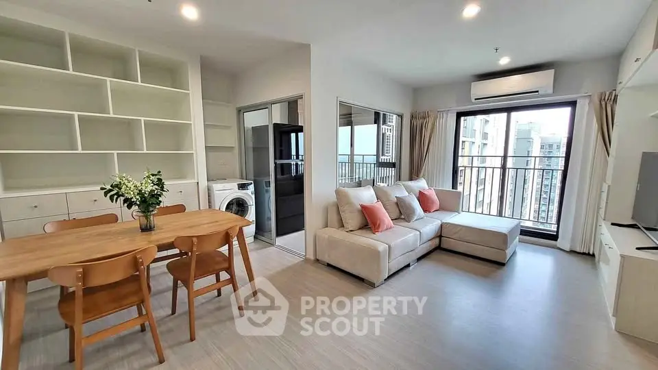 Modern living room with open layout, stylish furniture, and balcony view in a high-rise apartment.