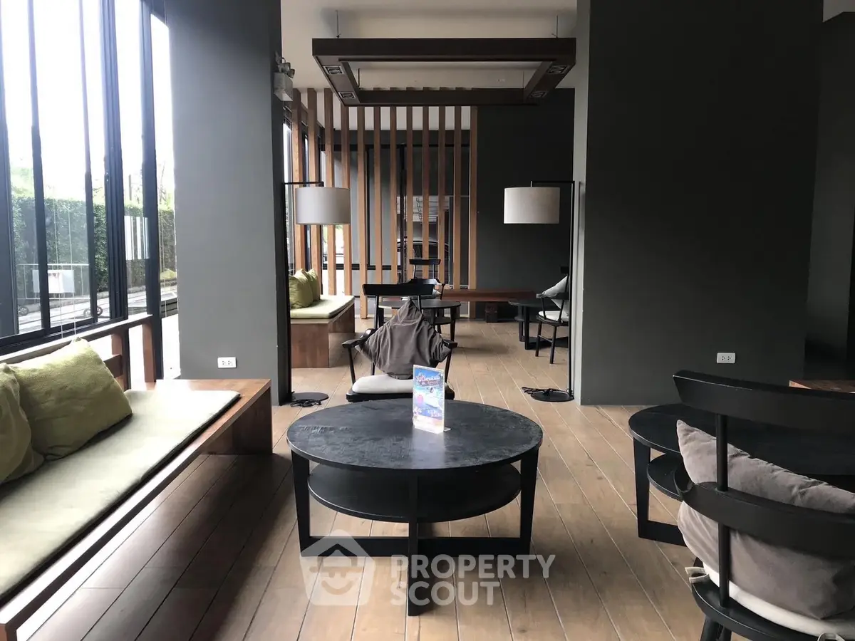 Modern communal lounge with stylish seating and large windows offering natural light.