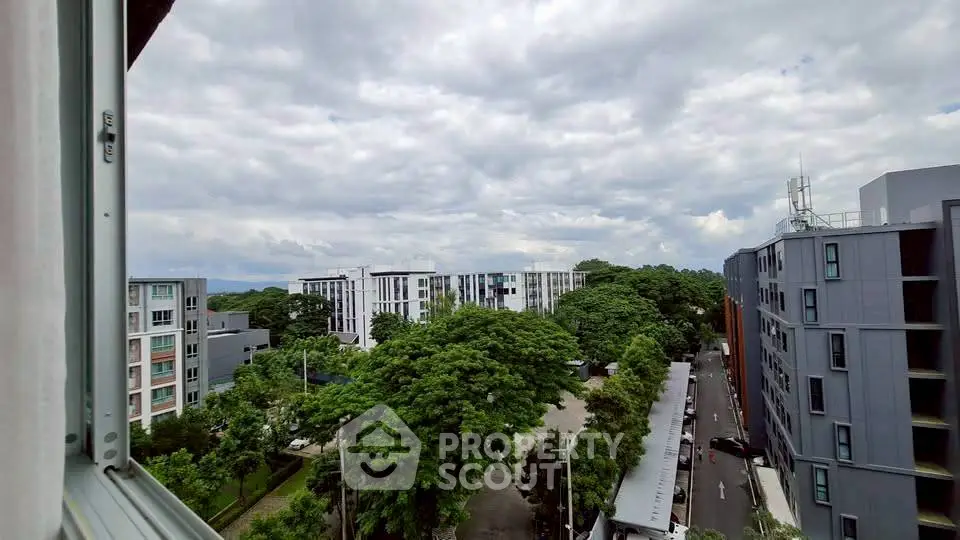 Stunning urban view from high-rise apartment with lush greenery and modern buildings.