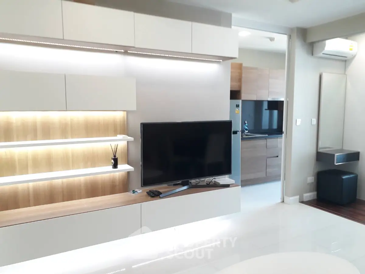 Modern living room with sleek TV unit and open kitchen layout