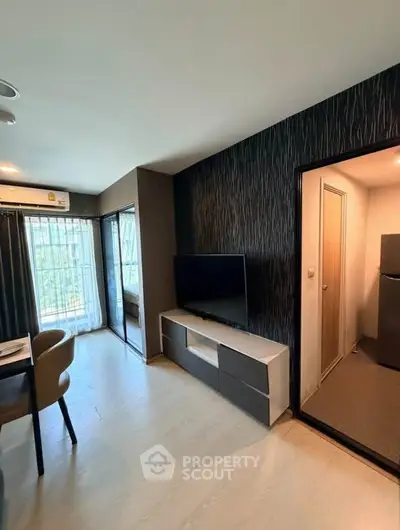 Modern living room with sleek TV unit and dining area, featuring a view of the balcony.