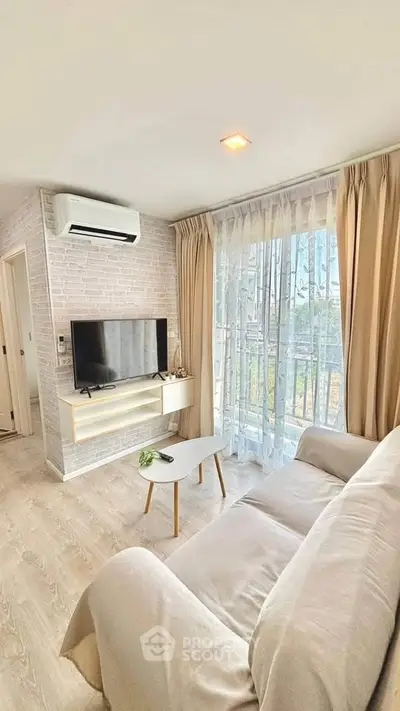 Bright and cozy living room with modern decor and large window view.