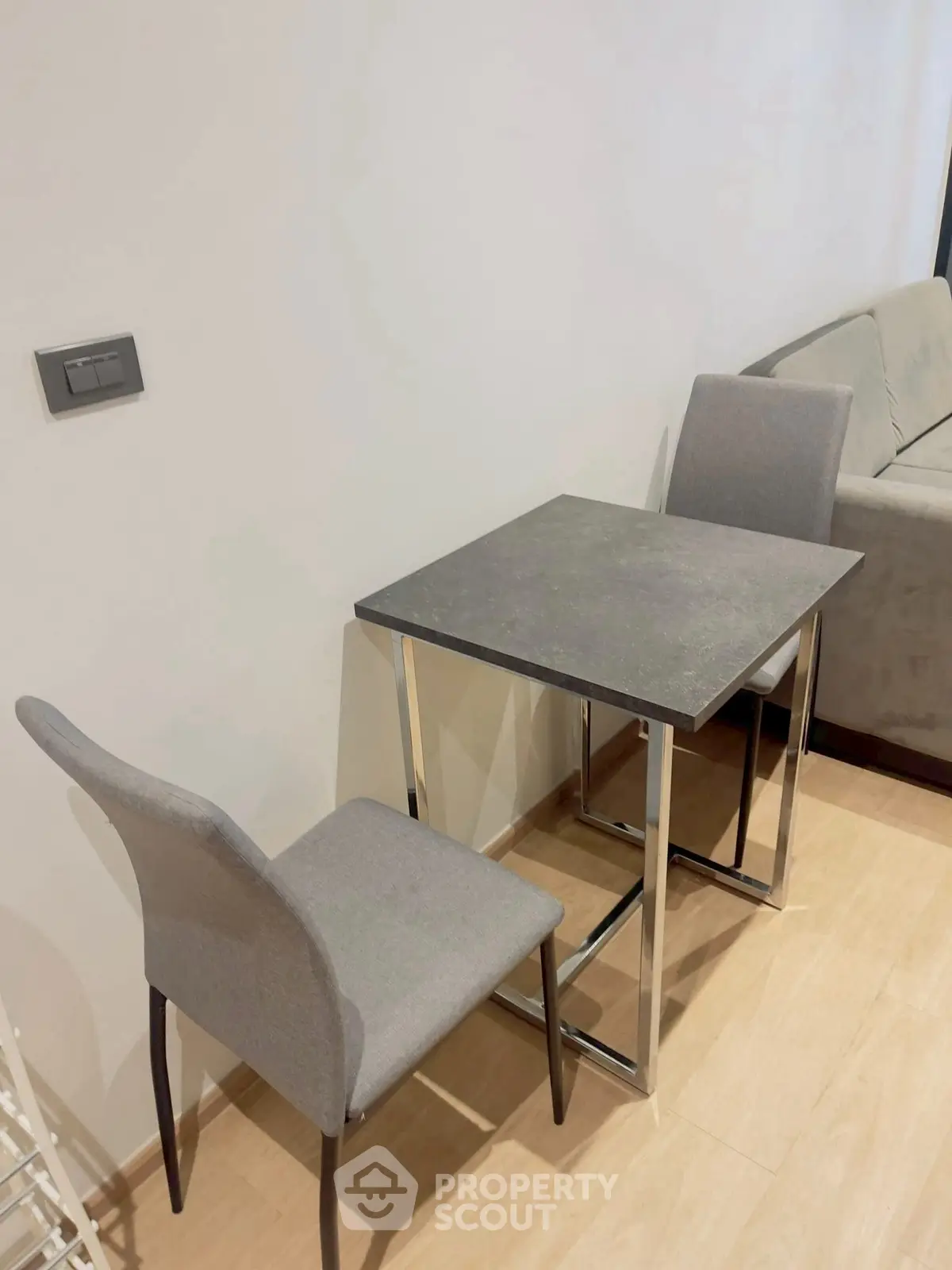 Modern minimalist dining area with sleek table and chairs in cozy apartment.