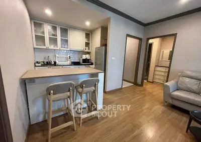 Modern open-layout kitchen with cozy seating and sleek appliances in a stylish apartment.