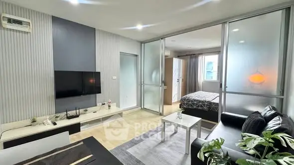 Modern open-plan living room with sleek decor and bedroom view