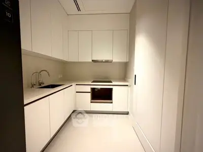 Modern minimalist kitchen with sleek white cabinetry and built-in appliances