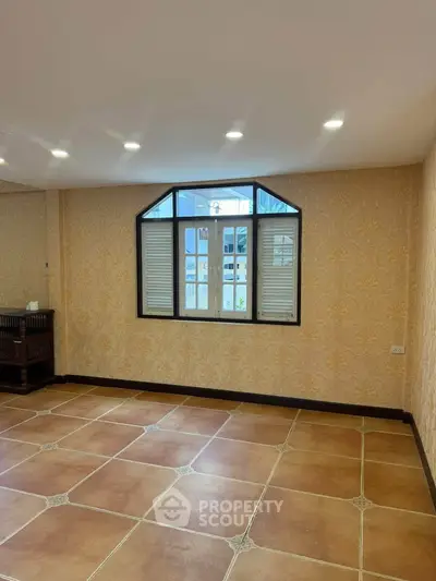 Spacious room with elegant tiled flooring and stylish window design