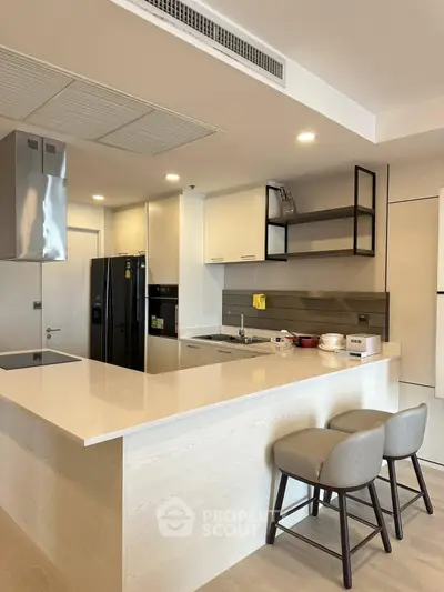 Modern kitchen with sleek design and open layout featuring island seating and high-end appliances.