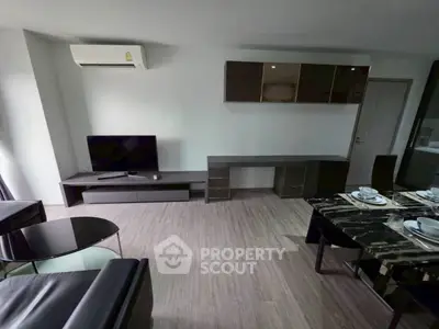 Modern living room with sleek furniture and dining area, featuring air conditioning and stylish decor.