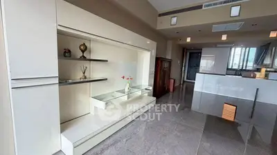 Modern living room with sleek built-in shelving and glossy tiled floors in a stylish apartment.