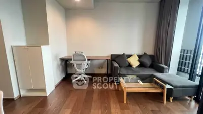 Modern living room with sleek furniture and wooden flooring, featuring a cozy sofa and study desk.