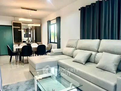 Modern living room with stylish furniture and elegant dining area, featuring a plush sectional sofa and chic decor.