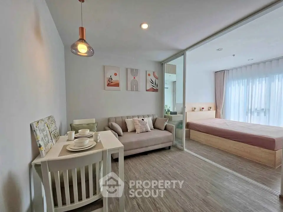 Modern studio apartment with cozy living area and bedroom, featuring stylish decor and natural light.