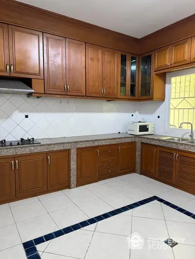 Spacious kitchen with wooden cabinets and modern appliances in a stylish home.