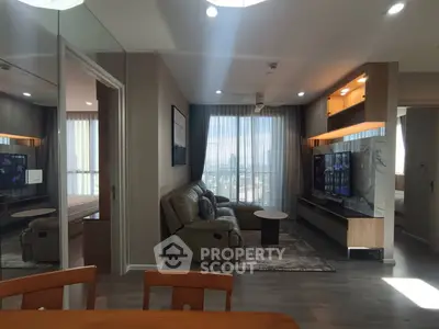 Modern living room with sleek furniture and large windows offering a stunning city view.