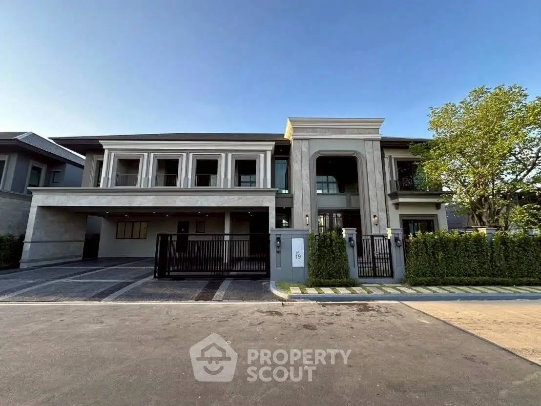 Luxurious modern mansion with grand entrance and spacious driveway in upscale neighborhood.