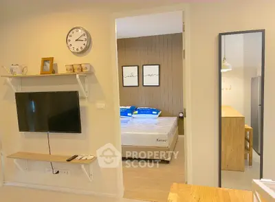 Modern apartment interior with wall-mounted TV and cozy bedroom view