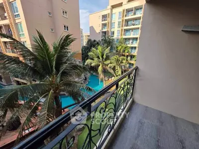 Stunning balcony view overlooking a tropical pool and lush palm trees in a modern apartment complex.