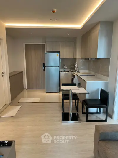 Modern open-layout kitchen with sleek appliances and dining area in a stylish apartment.
