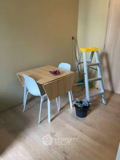 Cozy interior space with wooden table, chairs, and ladder, ideal for small dining or work area.