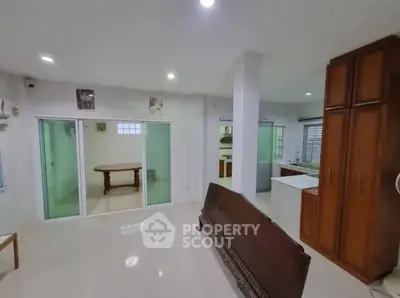 Spacious open-layout living area with modern kitchen and elegant wooden furniture.