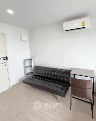 Modern living room with sleek black sofa and air conditioning unit