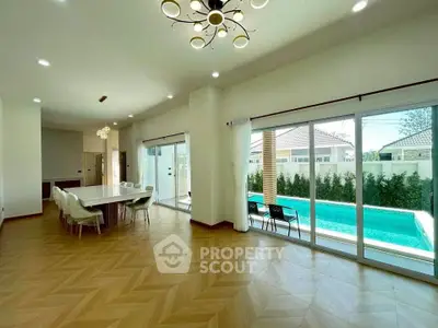 Spacious modern living room with pool view and elegant dining area