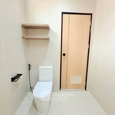 Modern minimalist bathroom with sleek toilet and wooden door